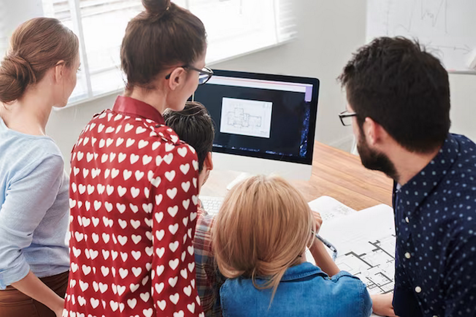 Group of people in an office near a computer